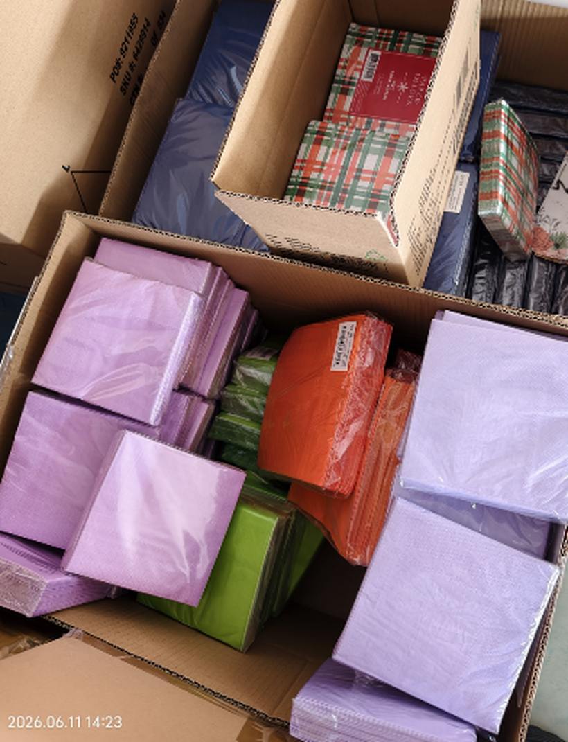 Mixed color and plaid pattern napkin sample cartons in warehouse corner